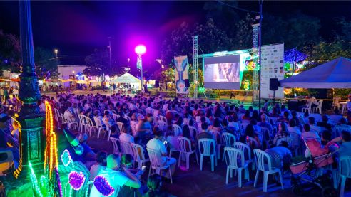 Proyección pública y nocturna de una película en una tarima dispuesta para una edición anterior del festival