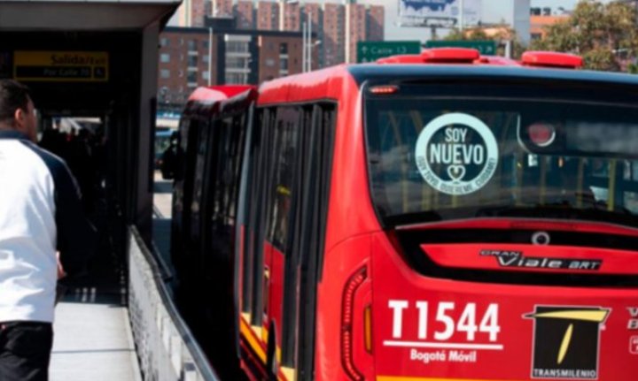 Imagen de un bus de Transmilenio y un hombre pasando en la estación 